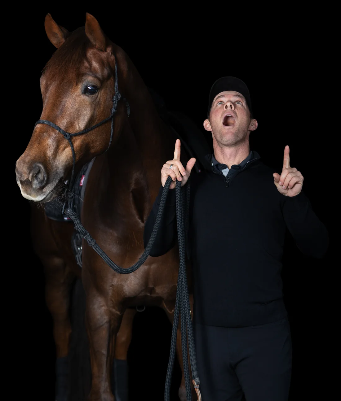 Tristan Tucker with a chestnut horse, pointing up