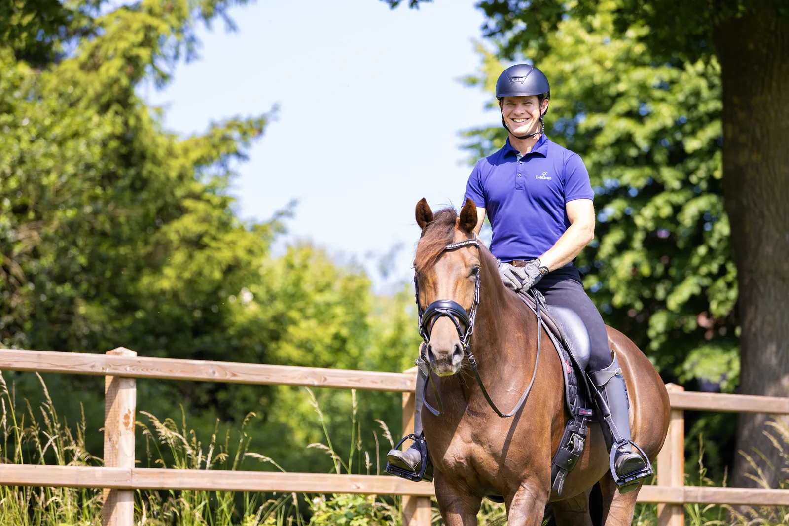 A smiling rider on a relaxed horse in the summer sun