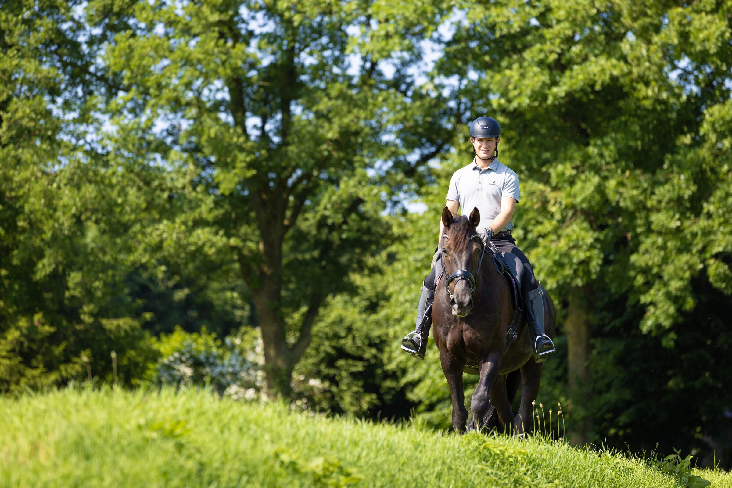 A rider on a calm, relaxed horse in an open field
