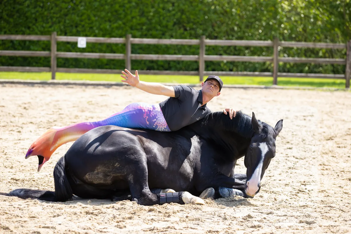 Tristan Tucker relaxing with a horse in the arena