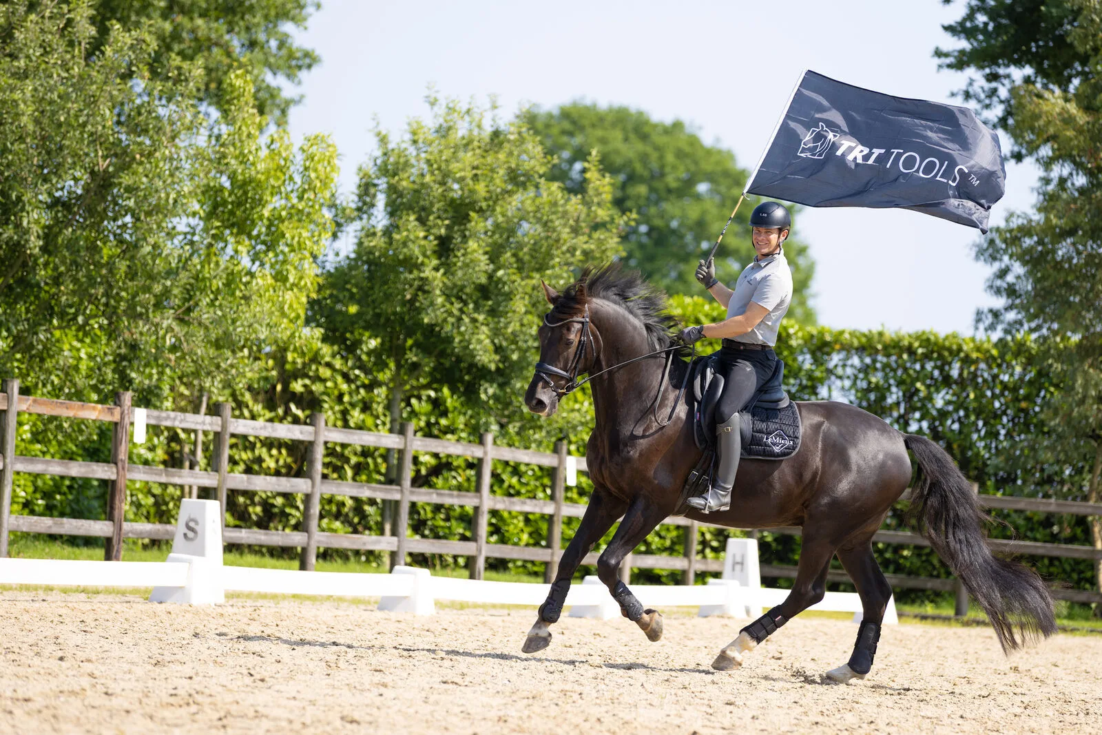Tristan riding a horse while carrying a large flag