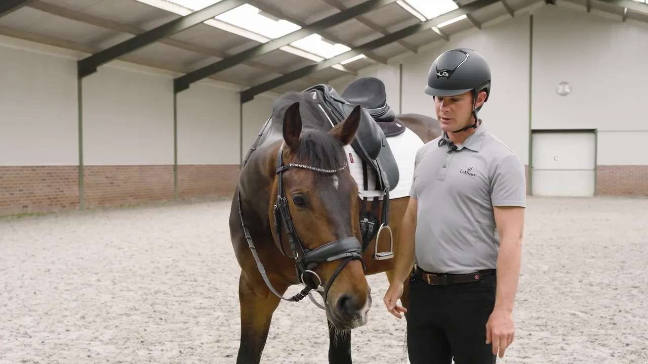 Tristan Tucker preparing a saddled horse for tension release from the saddle