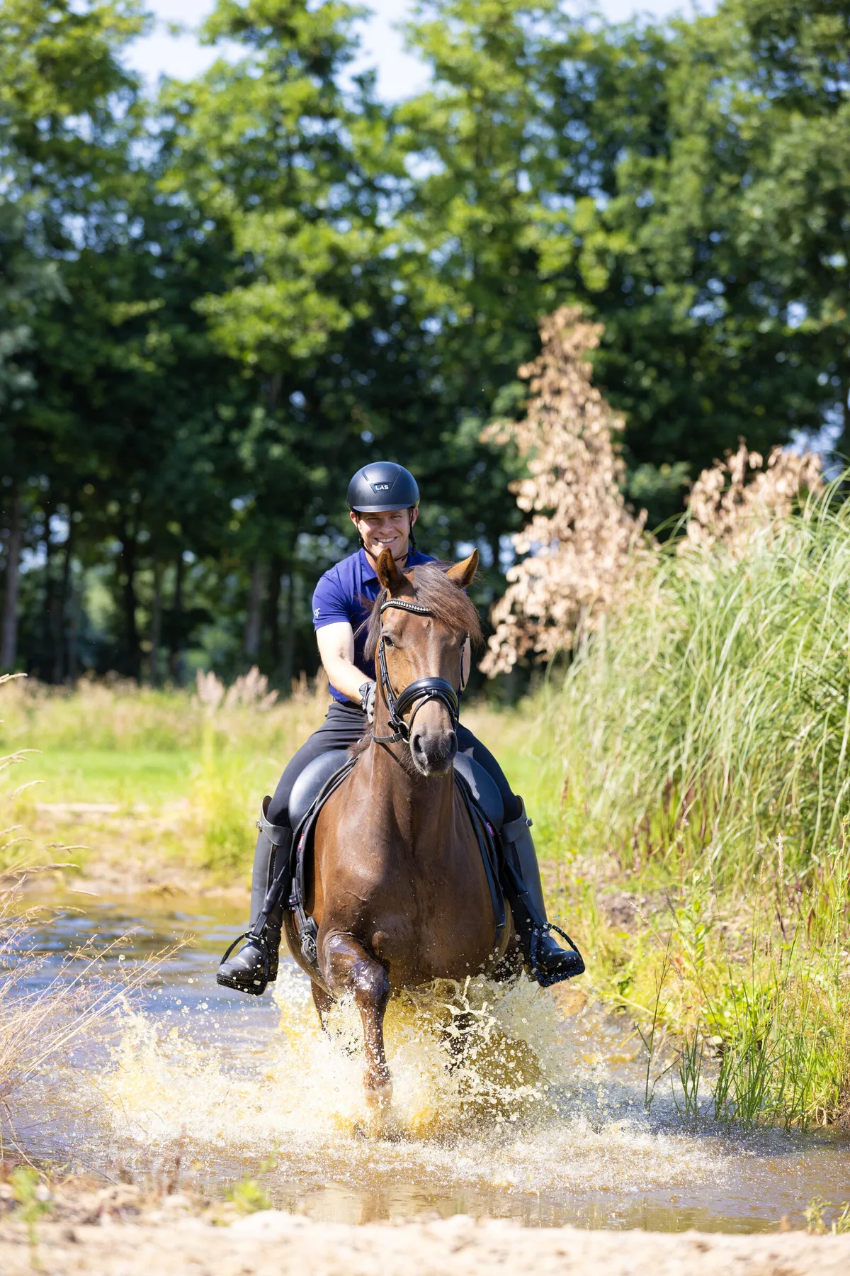 Tristan Tucker cantering a relaxed horse through splashing water